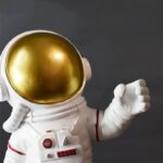 Cosmonaute en figurine décorative avec casque doré et combinaison blanche, idéale pour la décoration de science et d'espace.