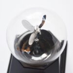Puce électrique avec hélice miniature dans une ampoule en verre, illustrant un objet scientifique décoratif.