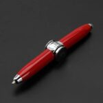 Stylo à bille élégant avec corps en métal rouge et détails en chrome, idéal pour la décoration de bureau ou comme objet scientifique.