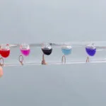 Bâtonnets transparents avec liquides colorés en suspension, utilisés pour des expériences scientifiques ou la décoration.
