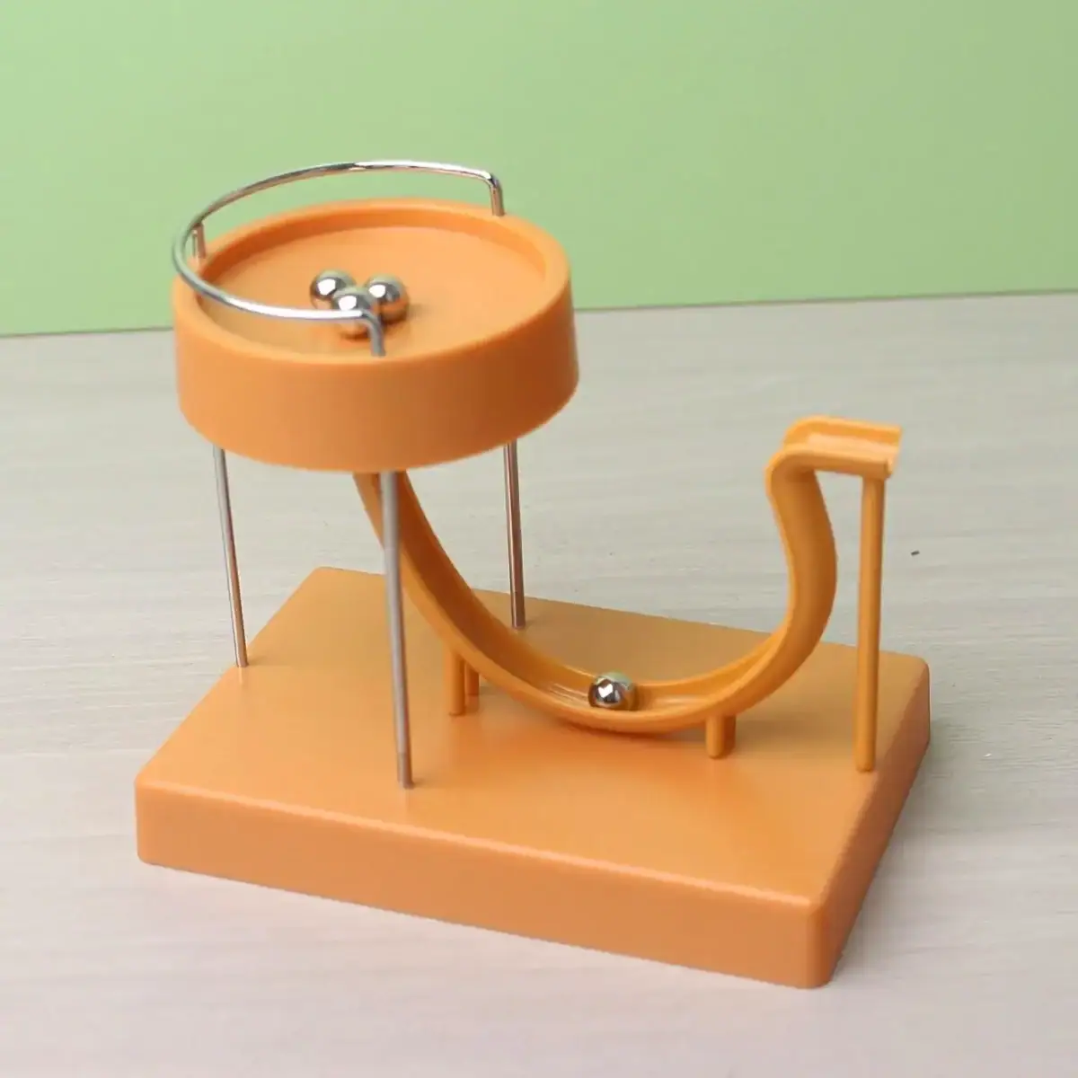 Balancier à billes pour expérience de physique, illustrant la conservation de l'énergie et la dynamique des corps en mouvement.