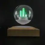 Lampe décorative en forme de boule de cristal avec graphique lumineux vert, posée sur une base en bois, idéale pour la décoration scientifique ou moderne.