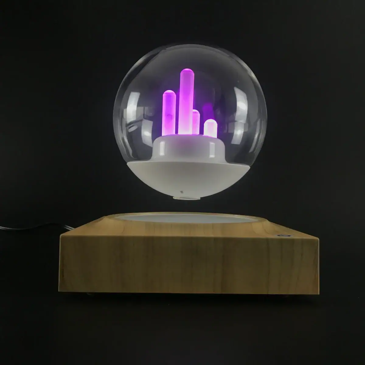 Lampe scientifique avec tubes lumineux violets dans une sphère en verre, posée sur une base en bois.