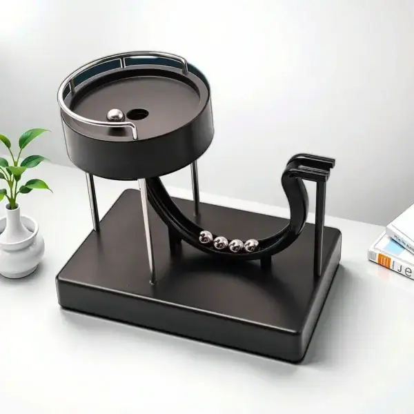 Bille de Newton de bureau en métal noir avec base, illustrant la loi de la conservation de la quantité de mouvement, idéale pour la décoration scientifique.