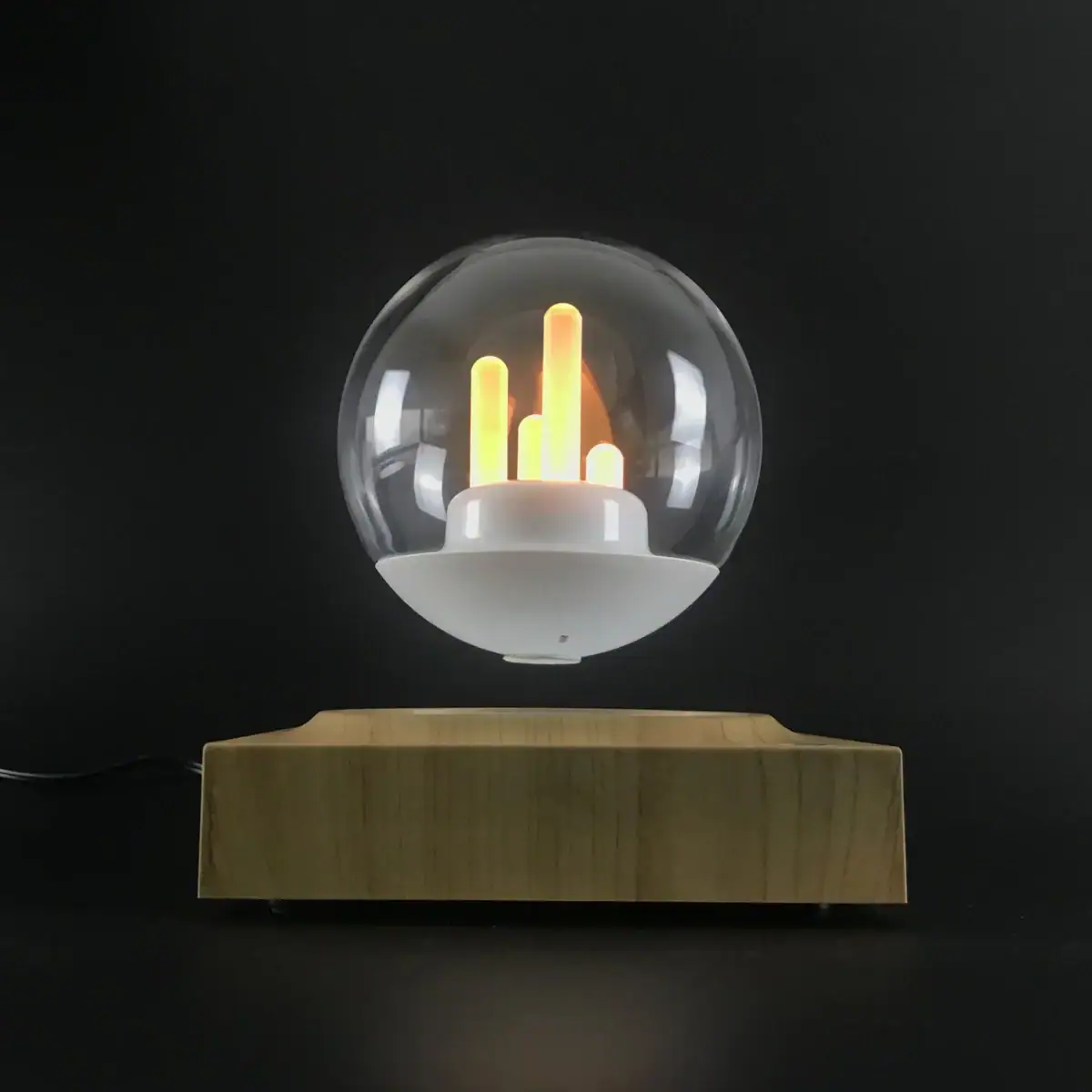 Lampe décorative en verre avec pulsations lumineuses jaunes et orange, posée sur une base en bois, création moderne pour décoration scientifique ou design intérieur.