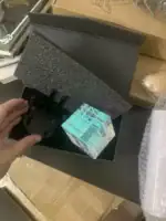 Pendentif en verre scientifique avec support métallique, présenté dans une boßte noire, idéal pour décoration ou collection scientifique.