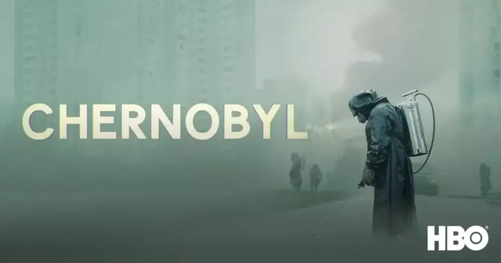 A firefighter in protective gear spraying water amidst a smoky, devastated Chernobyl landscape with ruined buildings and a hazy sky.