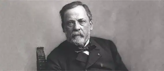 Portrait of a 19th-century scientist with a serious expression, wearing formal attire including a bow tie, seated against a plain background.