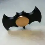 Porte-clés Batman en métal avec design de chauve-souris noir et centre doré, parfait pour les fans de super-héros et la décoration de bureau ou sac à main.