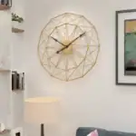 Horloge murale moderne en métal doré avec design géométrique, idéale pour la décoration intérieure contemporaine.