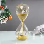 Sablier en verre transparent avec sable doré qui coule lentement, idéal pour la décoration ou comme objet de collection.