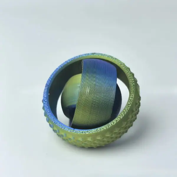 Balle de tennis transformée en objet décoratif avec un globe en verre coloré à l'intérieur, créant une pièce unique et artistique pour la décoration intérieure ou de bureau.