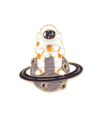 Pin's d'astronaute dans l'espace avec planète et étoiles.