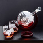 Objet scientifique décoratif avec globe terrestre et liquide rouge dans un support en bois.