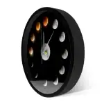 Horloge murale représentant les différentes phases de la lune, avec un design minimaliste noir et des détails en nuances de gris et orange, idéale pour la décoration scientifique.