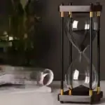 Sablier scientifique en verre avec cadre en bois et éléments métalliques dorés, idéal pour la décoration de bureau ou d'étagère avec un style industriel ou scientifique.