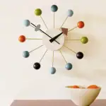 Horloge murale moderne avec sphères colorées en bois, design contemporain pour décoration intérieure.