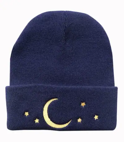 Bonnet en laine bleu marine orné d’un motif lune et étoiles dorées, parfait pour l’hiver ou comme accessoire de mode original.