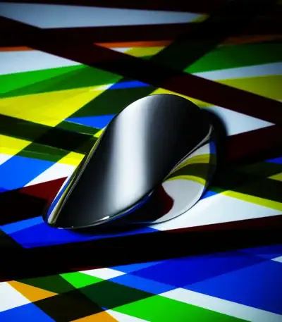 Pointeur de souris noir brillant placé sur un fond coloré abstrait avec des lignes diagonales multicolores.