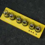 Panneau de contrôle scientifique avec 6 boutons lumineux sur fond jaune, utilisé pour des expériences ou démonstrations en laboratoire ou en éducation.