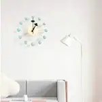Horloge murale moderne avec éléments en forme de sphères bleues.