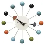 Horloge murale avec sphères colorées et aiguilles minimalistes.