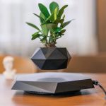 Vase magnétique en lévitation avec plante verte, décoration innovante et moderne.