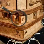 Pointeur sur un puzzle en bois avec une loupe pour explorer les détails.