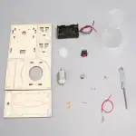 Ensemble de composants pour montage expérimental, incluant un panneau en bois, moteur, pile, interrupteur, ampoule, et divers petits accessoires, destiné à des projets éducatifs ou scientifiques.