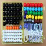 Billes colorées en plastique avec accessoires pour jeux éducatifs et activités manuelles.