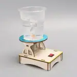 Réacteur chimique miniature en bois avec récipient en plastique pour expériences éducatives.