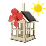 Modèle de petite maison solaire avec moulin à vent en plastique rose et panneau solaire noir, illustrant une éolienne domestique écologique.
