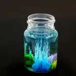 Vase en verre contenant une expérience scientifique avec des liquides colorés et des bulles, illustrant un phénomène chimique ou physique captivant.