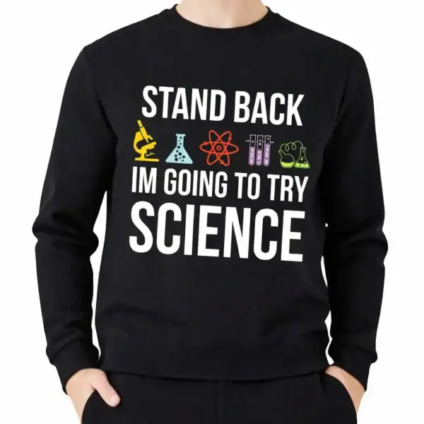 Une veste à capuche noire avec le texte "Stand Back, I'm Going to Try Science" et des icônes de laboratoire colorées, idéale pour les amateurs de science et de décoration scientifique.