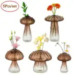 Vases en verre transparent avec couvercle en forme de champignon, contenant des fleurs artificielles colorées, idéal pour décoration de maison ou bureau.
