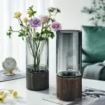 Vase en verre transparent avec socle en bois, idéal pour la décoration intérieure et la présentation de fleurs fraîches ou artificielles.