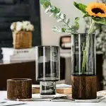 Vase en verre avec base en bois, idéal pour fleurs fraîches ou artificielles, apportant une touche naturelle et élégante à votre décoration.